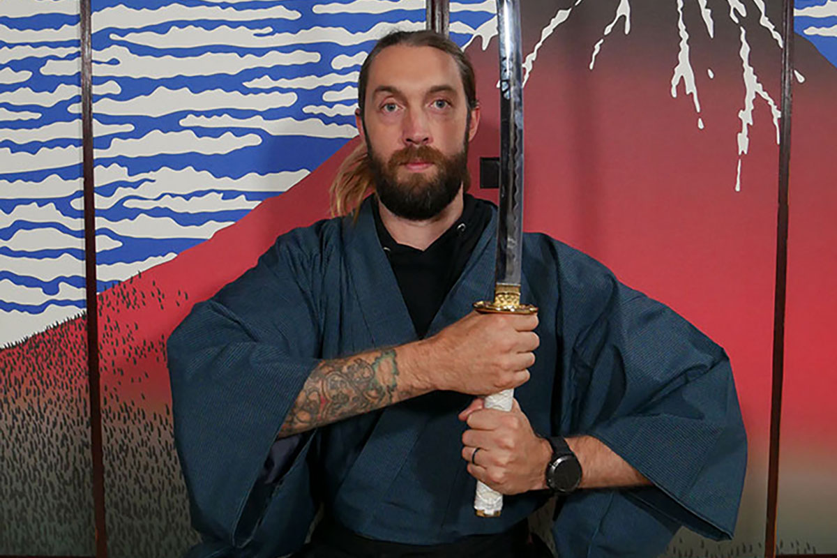 An Australian holding a sword and striking a pose